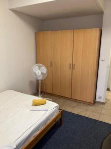 ブラチスラヴァにあるTerrace Rooms Rentalのベッドルーム(ベッド1台、木製キャビネット付)