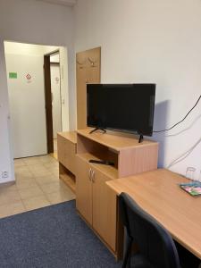 an office cubicle with a flat screen tv on a desk at Terrace Rooms Rental in Bratislava