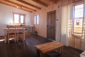 a living room with a table and a wooden table and chairs at Ocho Aguilas Eco Lodge in Guanaqueros