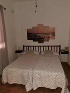 1 dormitorio con cama con edredón en VILLA DURÁN ESTEBAN, en Cantillana
