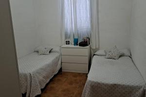 1 dormitorio con 2 camas y ventana en VILLA DURÁN ESTEBAN, en Cantillana