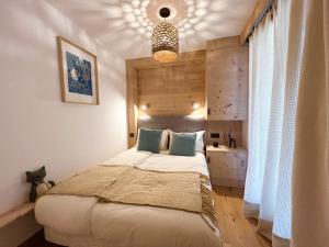 a bedroom with a bed and a chandelier at Mont Blanc 25, vue Mont blanc, balcon, parking in Chamonix
