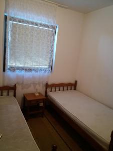 two beds in a small room with a window at Apartman - Sutomore in Sutomore