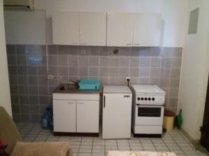 a kitchen with white cabinets and a white stove at Apartman - Sutomore in Sutomore