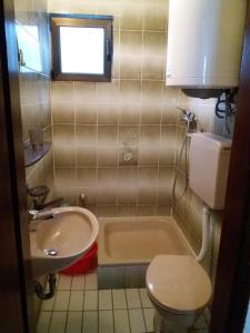 a bathroom with a sink and a toilet and a tub at Apartman - Sutomore in Sutomore