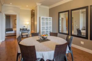 a dining room with a table and a bedroom at Cape Royale from McStay in Cape Town