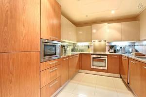 a large kitchen with wooden cabinets and stainless steel appliances at Cape Royale from McStay in Cape Town