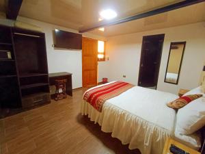 1 dormitorio con cama y escritorio. en La Posada del Viajero en Cusco