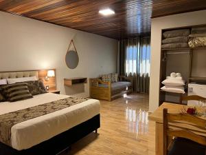 um quarto com uma cama, uma cadeira e uma mesa em Pousada Serra Geral em Cambará