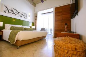 a bedroom with a large bed and a large window at Casa Claver Loft Boutique Hotel in Cartagena de Indias