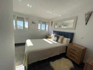 a bedroom with a large bed and a mirror at Seaside View Apartment in Estepona