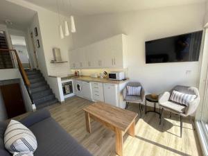 a kitchen and living room with a couch and a table at Seaside View Apartment in Estepona
