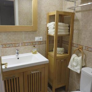 a bathroom with a sink and a shelf with towels at Seaside View Apartment in Estepona