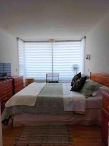 a bedroom with a bed and a large window at Bello depto a pasos de cavancha in Iquique