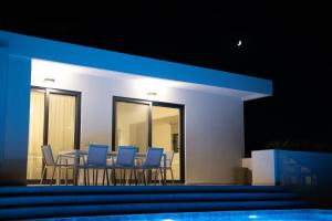 ein Esszimmer mit blauen Stühlen und einem Tisch in der Unterkunft Kyamon Estate Luxury Villa in Galangádhos