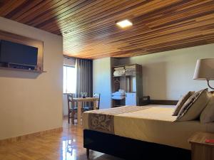 a bedroom with a large bed with a wooden ceiling at Pousada Serra Geral in Cambará