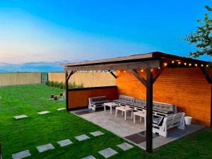 a pergola with benches and tables in a yard at Matt B in Vama Veche