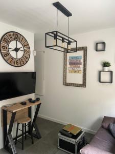 a living room with a table and a clock on the wall at Apartamento cama 105 ONTUR in Murcia