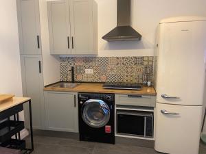 a kitchen with a washing machine and a refrigerator at Apartamento cama 105 ONTUR in Murcia