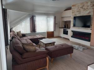 sala de estar con sofá y mesa en ЕЛЕГАНС къща за гости, en Dospat