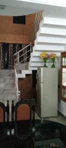 - un escalier avec deux vases de fleurs sur un réfrigérateur dans l'établissement Holiday homes in kidangoor kottayam kerala, à Kottayam