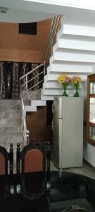 コッタヤムにあるHoliday homes in kidangoor kottayam keralaの冷蔵庫に花瓶2本付きの階段 +23枚の写真