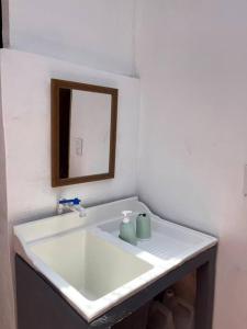 a bathroom with a white sink and a mirror at Buganvilla Quepos No 2 in Quepos