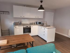 a kitchen with white cabinets and a wooden table at Tummock Studio perfect for exploring the North coast in Kilraghts