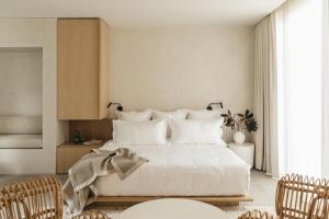 a bedroom with a large white bed with white pillows at Octavia Casa in Mexico City