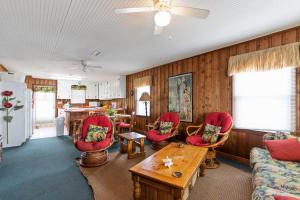 a living room with red chairs and a table at Yellow Bird in Holden Beach