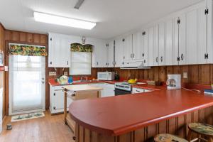 a kitchen with white cabinets and a large island in it at Yellow Bird in Holden Beach