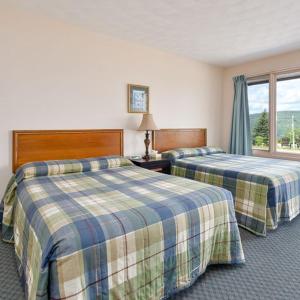 a hotel room with two beds and a window at Kelly's View Motel in Boularderie East