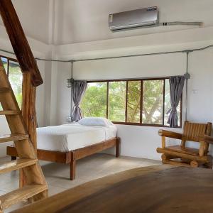 1 dormitorio con 1 cama, escalera y ventanas en Hotel Nantu Hostería, en Puerto López