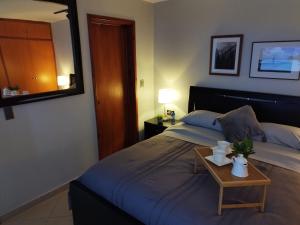 Un dormitorio con una cama con una mesa. en Chic y Hermoso Apartamento Amoblado y Equipado Urb El Parral Valencia-Venezuela, en Valencia