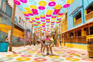 twee meisjes die onder een bos kleurrijke ballonnen staan bij Hotel Cantaritos in Rosarito
