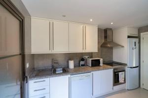 eine Küche mit weißen Schränken und einem weißen Kühlschrank in der Unterkunft Villa Lux Finestrat in Finestrat