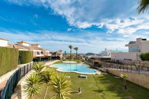 ein Swimmingpool in einem Garten mit Palmen in der Unterkunft Villa Lux Finestrat in Finestrat