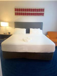 a large bed in a hotel room with a towel on it at Illini Inn & Suites in Rantoul