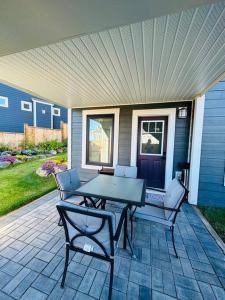 a patio with a table and chairs on a house at The Royal Bay Escape: Cozy 2 bedrooms garden suite in Colwood