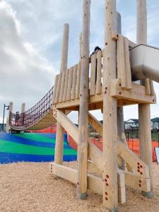 a wooden playground with a slide in a park at The Royal Bay Escape: Cozy 2 bedrooms garden suite in Colwood