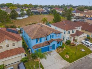 an overhead view of a blue house in a residential neighborhood at 5 Bedroom Villa l 12 min to Disney l Themed Rooms l Orlando Area in Davenport