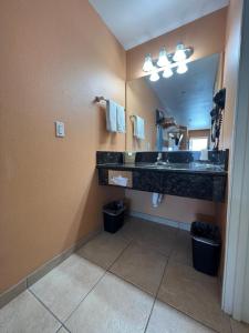 uma casa de banho com um lavatório e um espelho grande em Rancho California Inn Temecula em Temecula