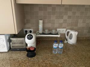 a kitchen counter with bottles of water and appliances at Casa do Calhau - AL in Hombres