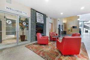 uma área de espera com cadeiras vermelhas e uma mesa numa loja em Best Western Plus Kelowna Hotel & Suites em Kelowna
