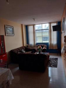 sala de estar con sofá y ventana grande en D-201, en Moyobamba