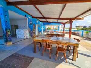 a dining room with a table and chairs and a blue wall at Manero Pousada e Hostel NATAL in Natal
