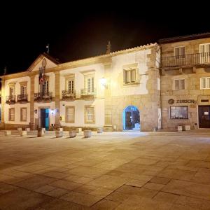 a large stone building with a courtyard at night at Casa da Praça in Miranda do Douro