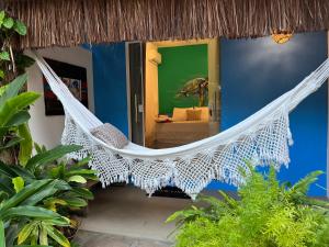 a hammock on the side of a house at Pousada Nascente do Sol in Ilha de Boipeba