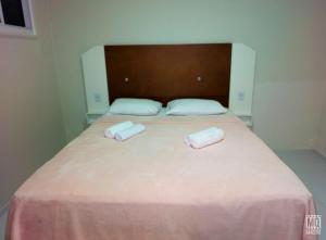 a bed with two towels on top of it at MANERO HOSTEL e POUSADA in Natal