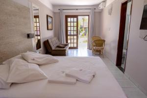 um quarto com uma cama branca com duas toalhas em Saint Germain - Lagoa da Conceição em Florianópolis